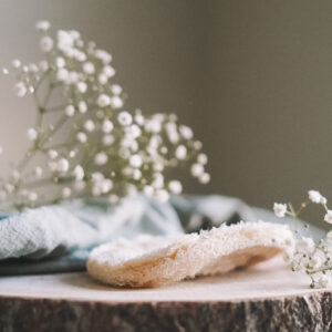 Porte-savon en luffah sur un tronc avec du gypsophile