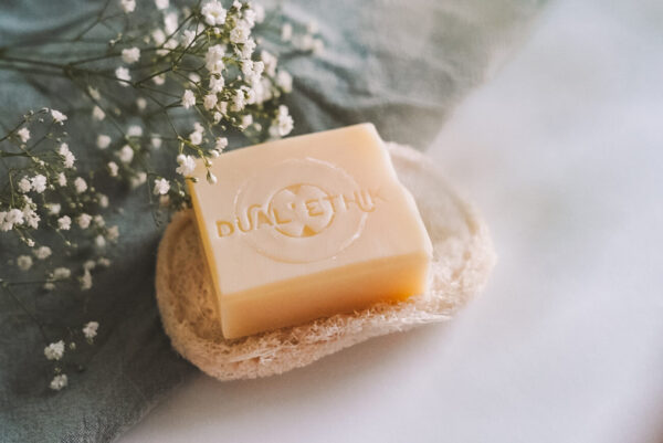 Le savon nature sur le porte-savon en luffah